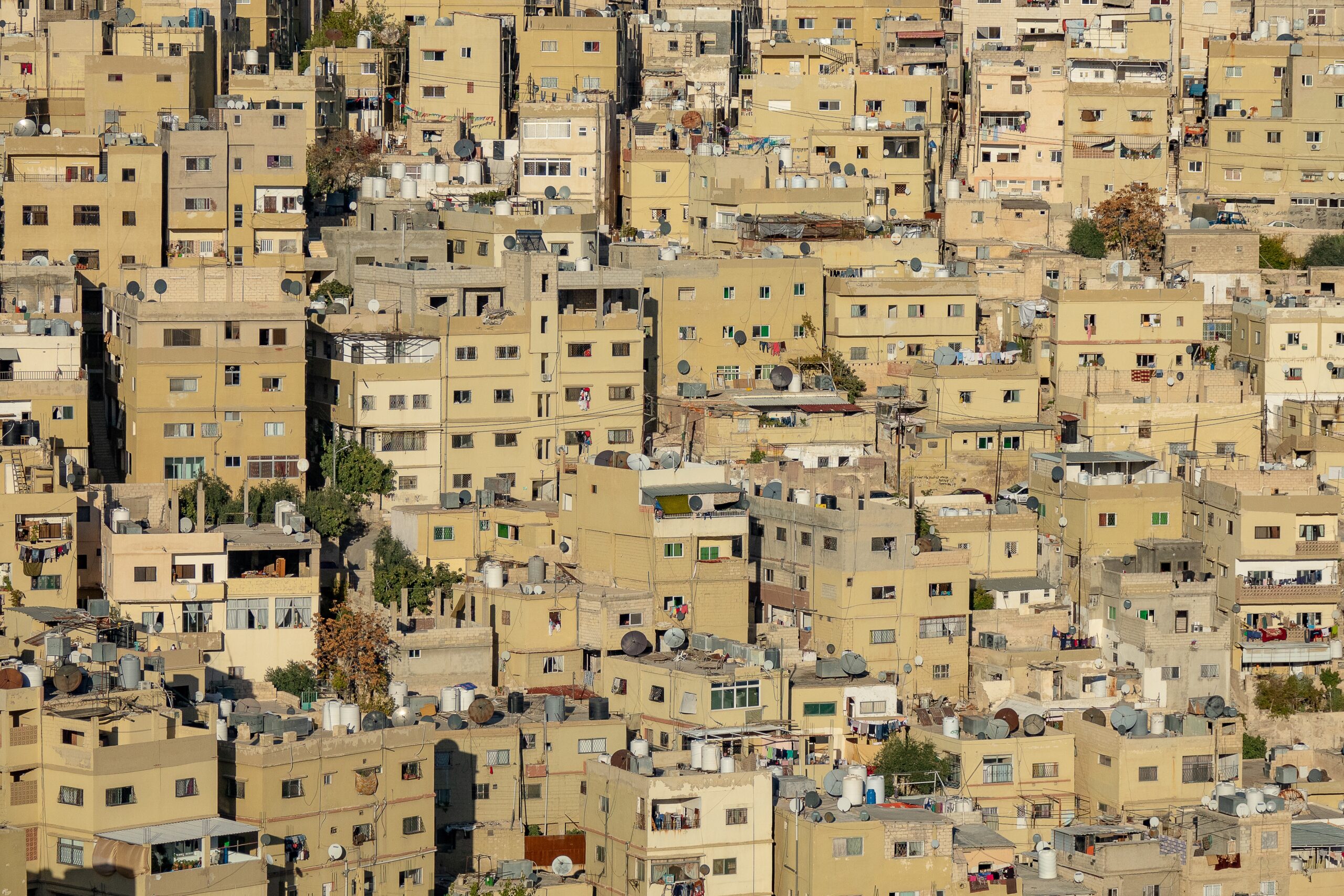 Many light brown buildings of a city constructed in close vicinity to each other