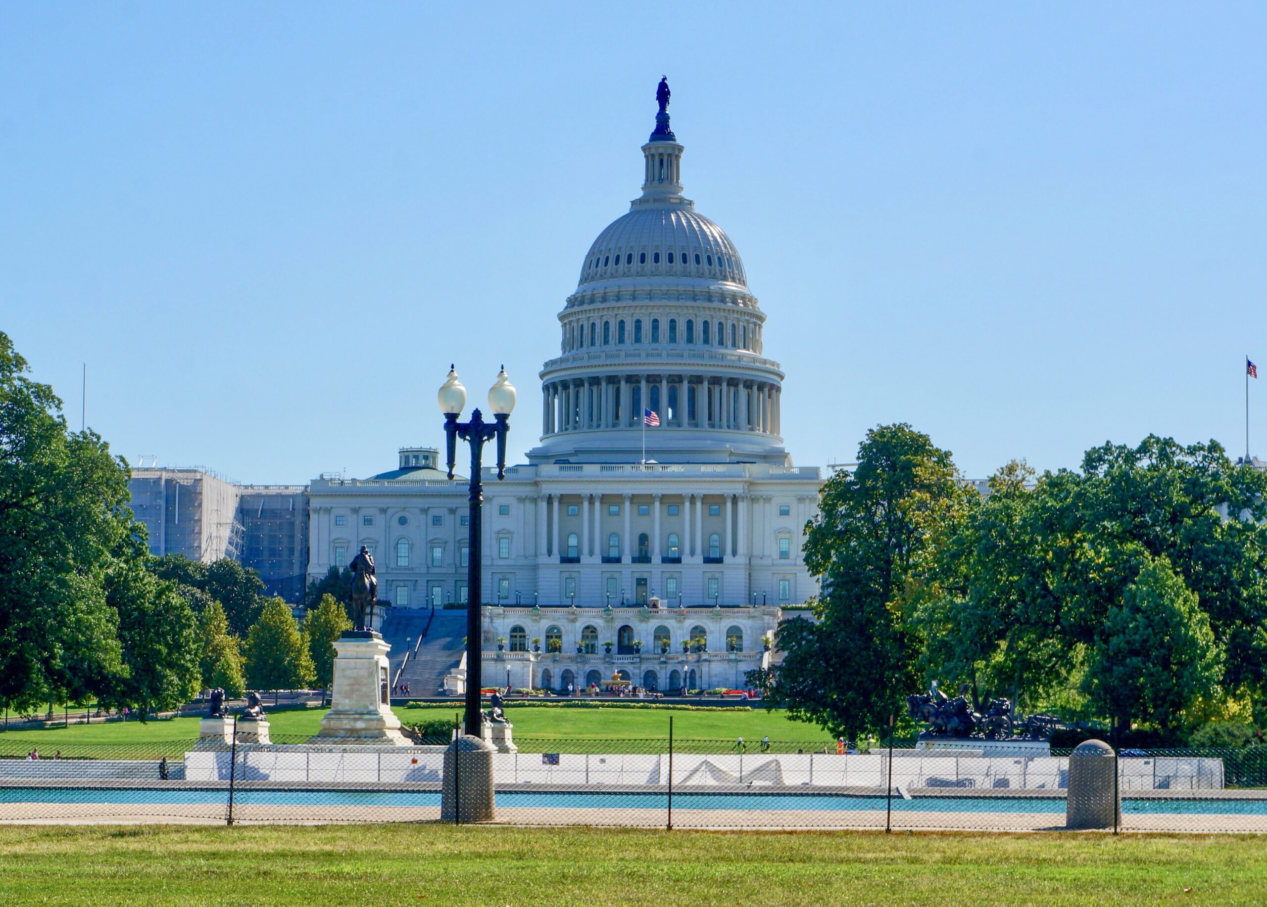 View of the United States Capitol Building in Washington, D.C., with the Capitol dome centered against a blue sky.