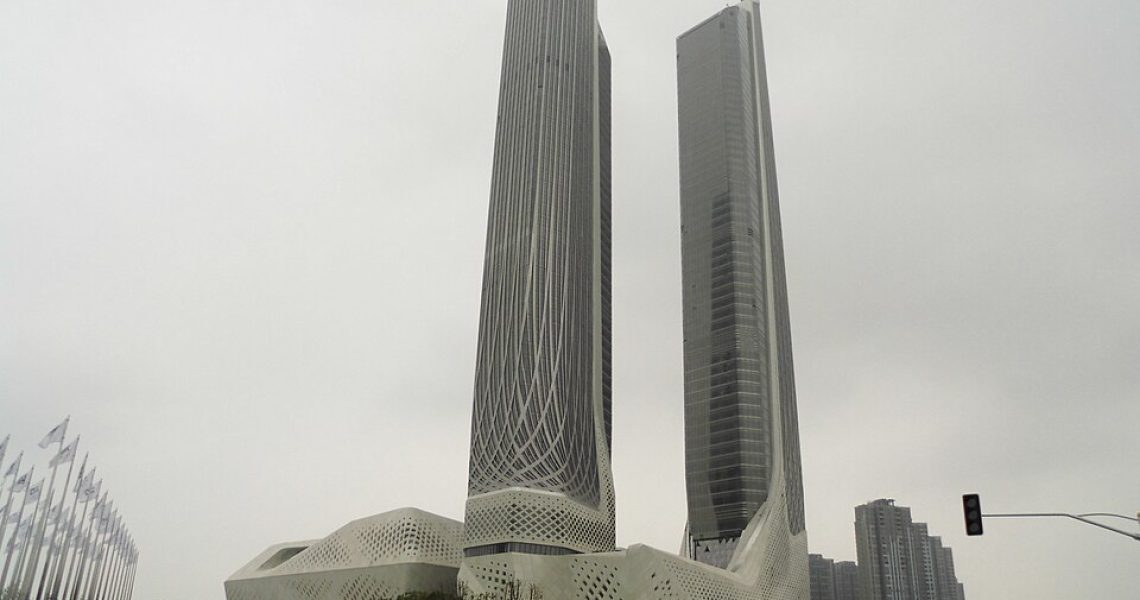 View of the Nanjing International Youth Cultural Centre in China, featuring two modern skyscrapers designed by architect Zaha Hadid against a cloudy sky.