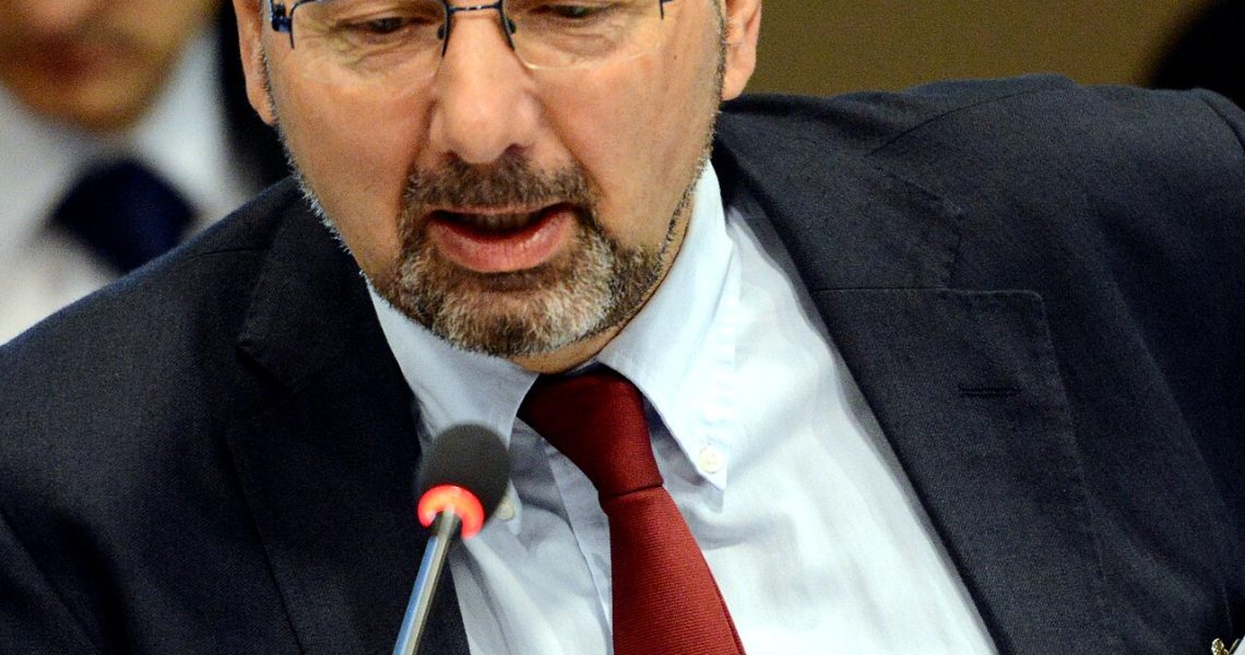 Political analyst and academic Richard Sakwa speaking into a microphone during a conference or panel discussion.