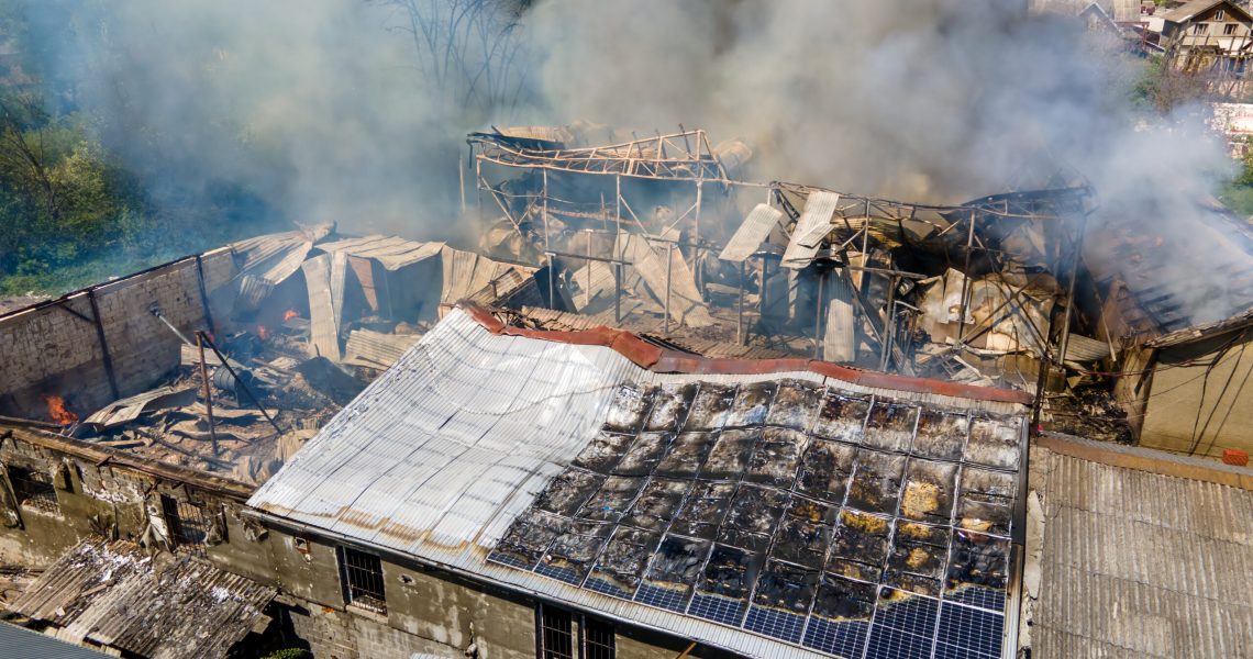 Ruined building on fire as example of rocket air strike result between Israel and Gaza in Middle East conflict.